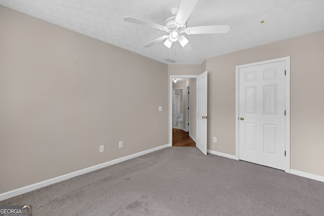 unfurnished bedroom featuring a ceiling fan, carpet flooring, a textured ceiling, and baseboards