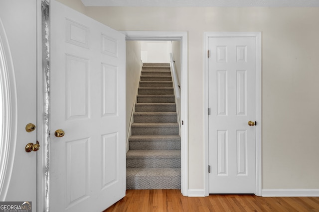 stairway featuring baseboards and wood finished floors