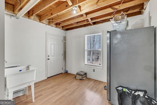 interior space featuring baseboards, freestanding refrigerator, and light wood-style floors