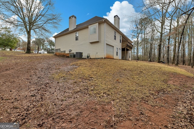 view of property exterior featuring a garage and a chimney