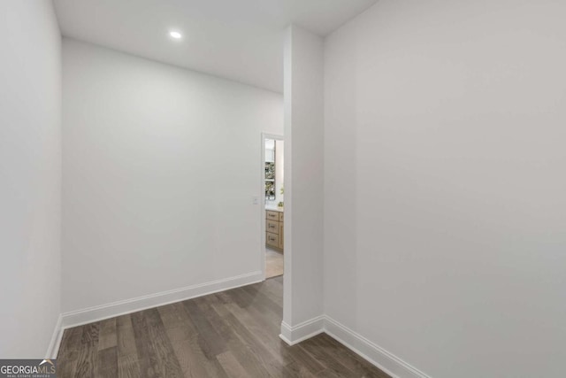 empty room featuring dark wood-style flooring, recessed lighting, and baseboards