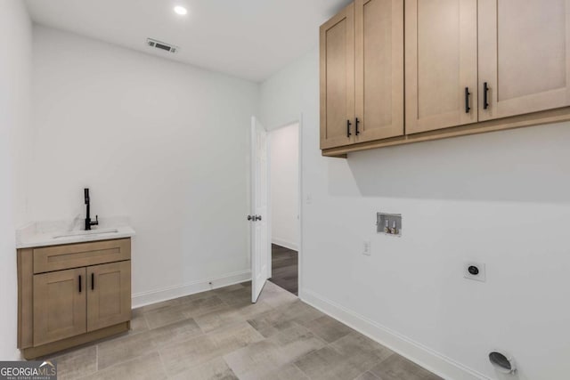 laundry room with hookup for a washing machine, hookup for an electric dryer, a sink, visible vents, and cabinet space