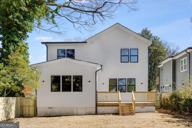 rear view of property featuring a deck, crawl space, and fence