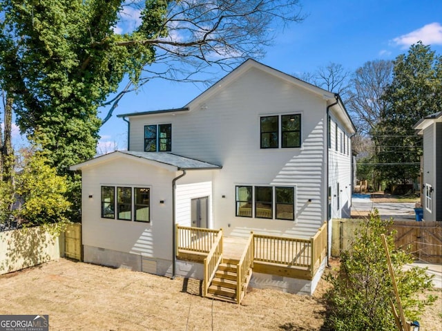 rear view of house featuring crawl space, fence, and a wooden deck