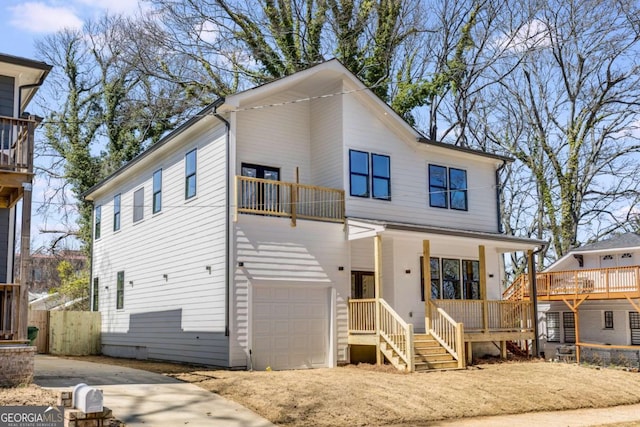 view of front facade with a garage, driveway, a porch, and a balcony