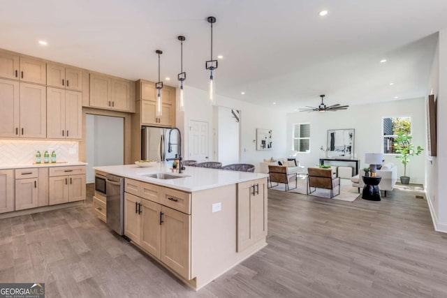 kitchen featuring light countertops, appliances with stainless steel finishes, light wood-type flooring, and decorative backsplash