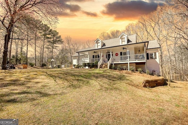 view of front facade featuring ceiling fan, a yard, and covered porch