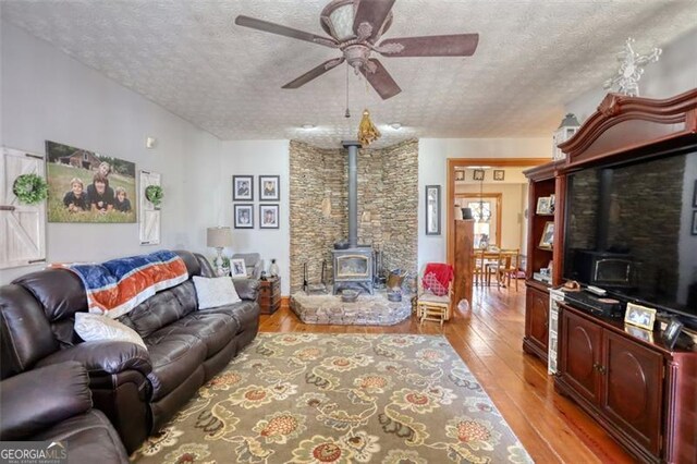 living area with a healthy amount of sunlight, ceiling fan, a textured ceiling, and light wood finished floors