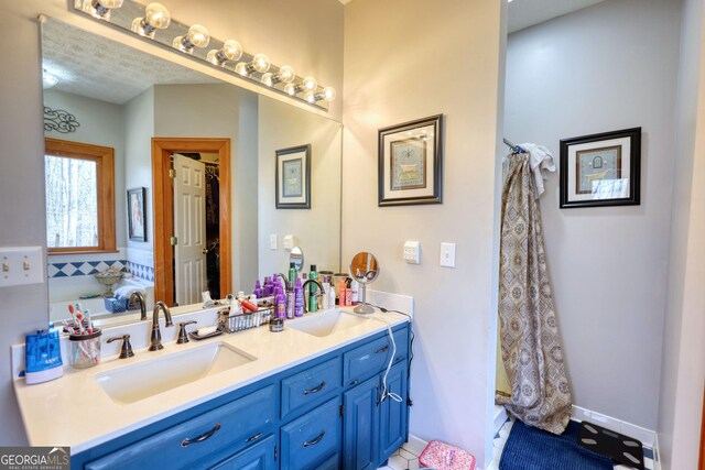 full bath featuring a wealth of natural light, a sink, and double vanity