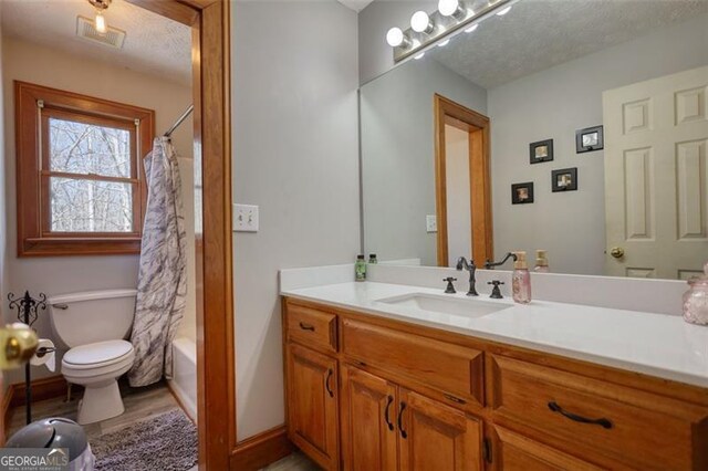 bedroom with multiple windows, visible vents, vaulted ceiling, and a textured ceiling