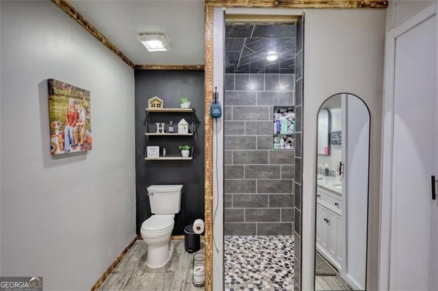 full bath with wood finished floors, a stall shower, vanity, and toilet