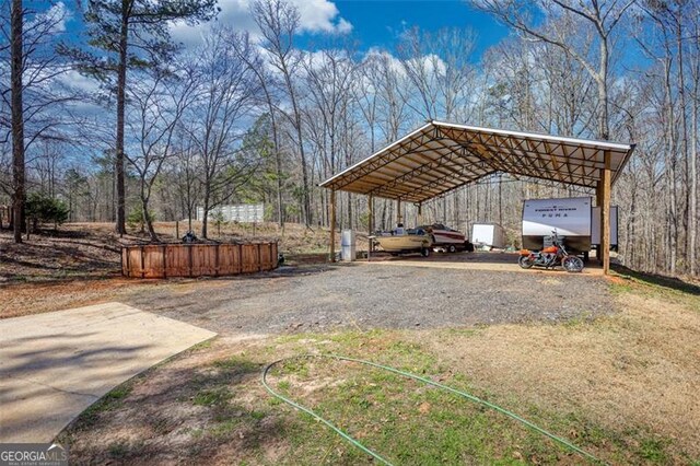 view of yard featuring a carport and gravel driveway