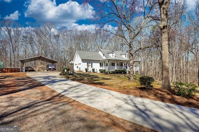 view of front of home featuring a carport, covered porch, concrete driveway, and a front yard