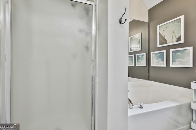 bathroom featuring a stall shower and a bath