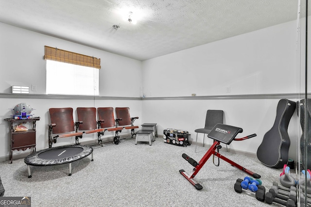 exercise area with a textured ceiling and baseboards