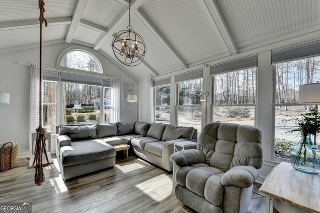 sunroom / solarium featuring vaulted ceiling with beams and a notable chandelier