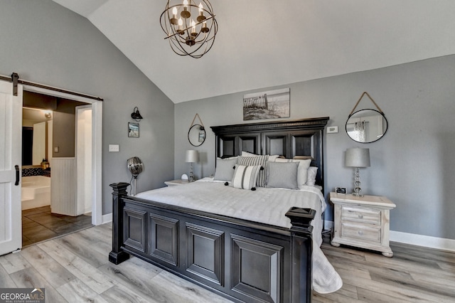 bedroom with lofted ceiling, light wood-style flooring, baseboards, and a barn door