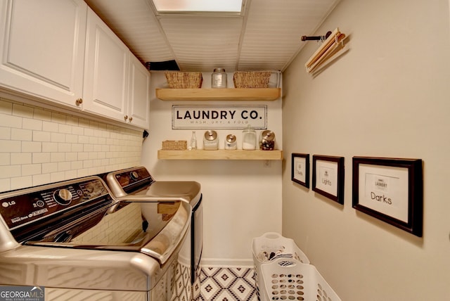 laundry area featuring washer and clothes dryer, cabinet space, and baseboards