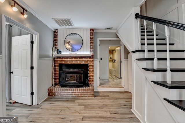 living room with stairway, visible vents, wood finished floors, and ornamental molding