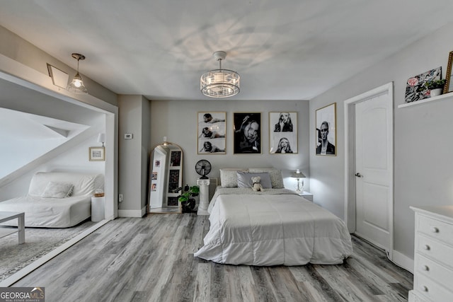 bedroom with arched walkways, a notable chandelier, wood finished floors, and baseboards