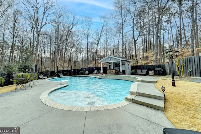 view of pool with fence private yard, an outdoor structure, a patio, and a storage structure