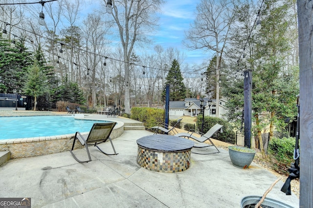 view of swimming pool featuring a fire pit, a patio, fence, and a fenced in pool