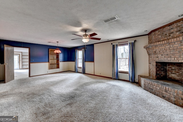 unfurnished living room featuring a textured ceiling, a brick fireplace, visible vents, and carpet