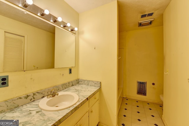 bathroom featuring visible vents, vanity, toilet, and baseboards