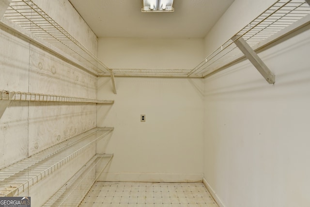 walk in closet with tile patterned floors