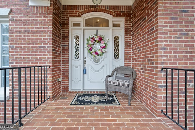 view of exterior entry featuring brick siding