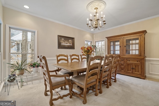 dining area featuring light carpet, crown molding, and an inviting chandelier