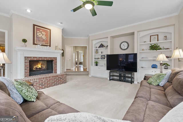 living room with light carpet, a ceiling fan, built in features, a brick fireplace, and crown molding