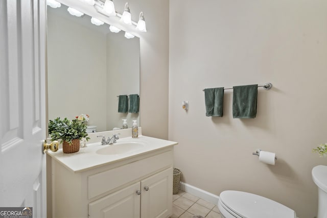 bathroom featuring toilet, vanity, baseboards, and tile patterned floors