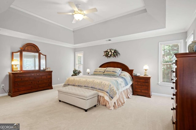 carpeted bedroom featuring crown molding, a raised ceiling, a ceiling fan, and baseboards