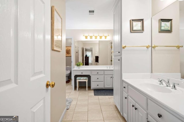 full bathroom featuring visible vents, toilet, a sink, tile patterned flooring, and two vanities