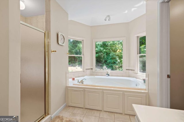 bathroom with a garden tub, a shower stall, and tile patterned floors