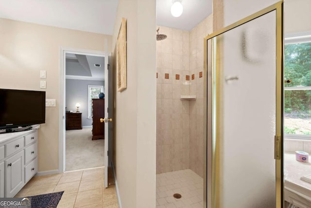 full bath with a stall shower, plenty of natural light, baseboards, and tile patterned floors