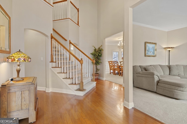 entryway with hardwood / wood-style flooring, baseboards, stairs, and ornamental molding