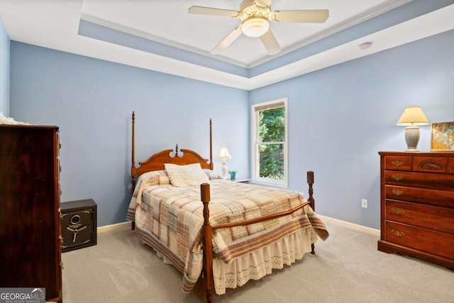 bedroom with carpet floors, a tray ceiling, a ceiling fan, and baseboards