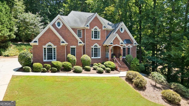 view of front facade with a front yard and brick siding