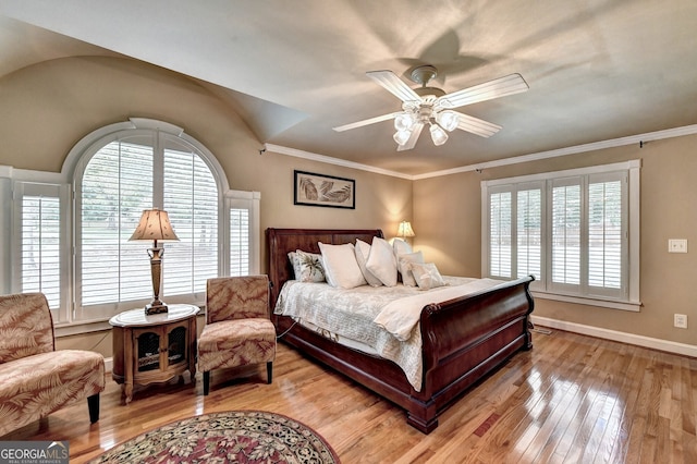 bedroom with ornamental molding, light wood-type flooring, multiple windows, and baseboards