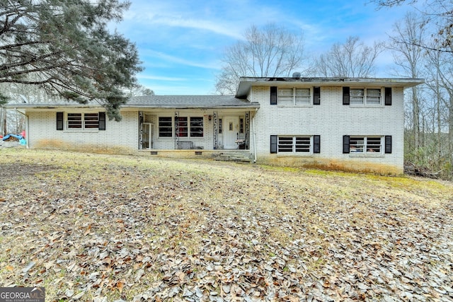 tri-level home with a porch and brick siding