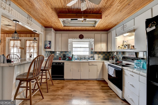 kitchen featuring tile countertops, light wood-style flooring, backsplash, wood ceiling, and black appliances