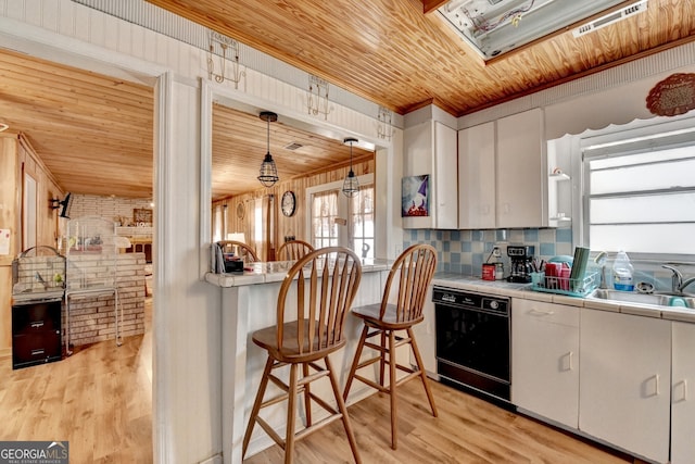 kitchen with wooden ceiling, a sink, light wood-style floors, tile counters, and dishwasher