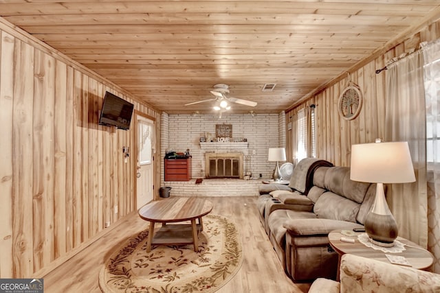 sitting room featuring brick wall, a fireplace, wood finished floors, visible vents, and wood ceiling