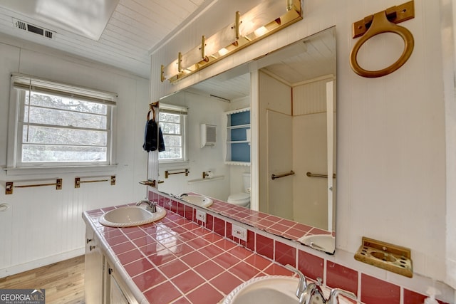 full bath with toilet, visible vents, wood finished floors, and vanity