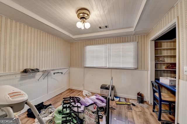 exercise room with light wood-type flooring, wallpapered walls, wood ceiling, and visible vents