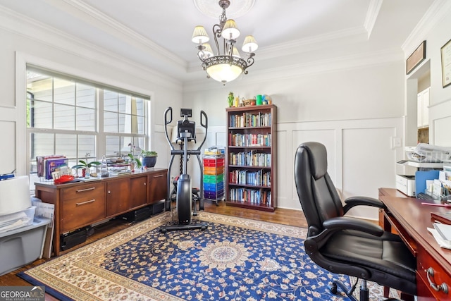 office featuring a chandelier, wainscoting, crown molding, and wood finished floors