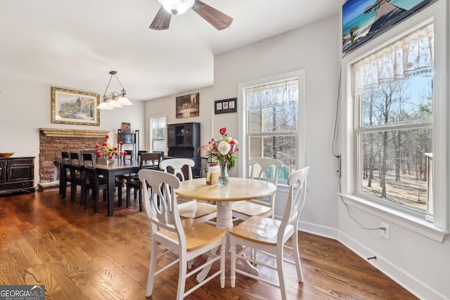 dining area featuring a ceiling fan, baseboards, and wood finished floors