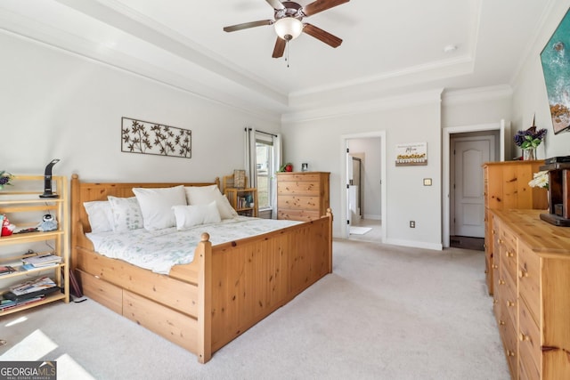 bedroom featuring light carpet, a tray ceiling, a ceiling fan, and crown molding